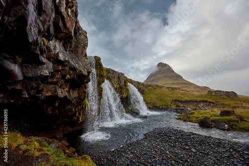 Kirkjufellsfoss waterfall with Kirkjufell cliff in the background in Iceland © di_ryan