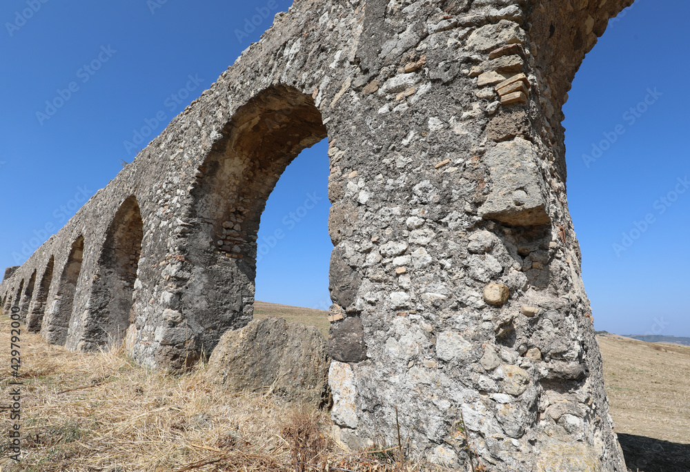 Roman aqueduct that runs in the middle of the field made with arches