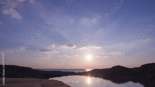 Amazing sunset with sunlight reflected on the water over seascape. Nature landscape in motion. High quality 4K resolution. Timelapse footage. photo