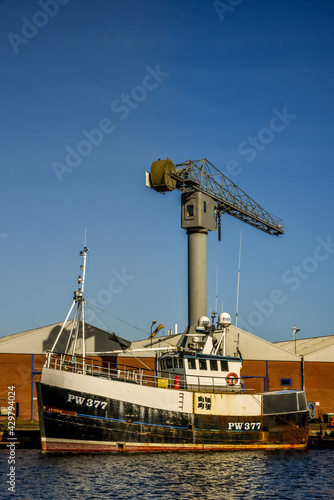 Tugboat with a crane on the background in the harbour of Den Helder, Netherlands.