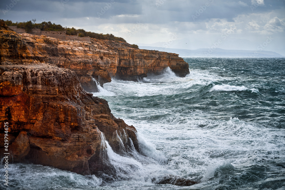 Obraz premium Stunning sea storm on a rocky shore.