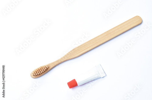 wooden toothbrush and little toothpaste tube arranging isolated on white background