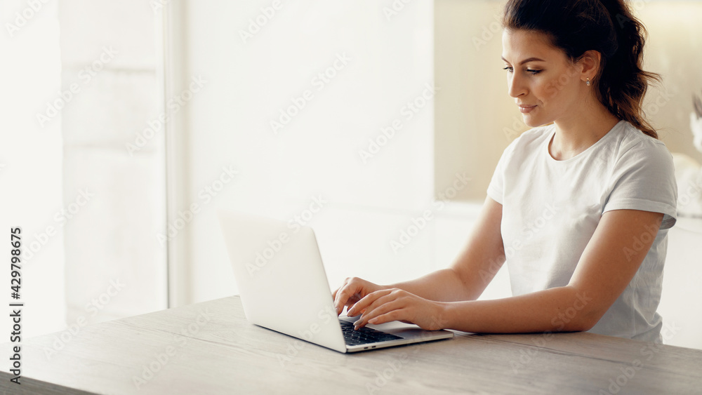 Young woman of European appearance online training on a laptop. A freelancer works by writing text on a computer. Communicates with friends via a social network. Young woman of European appearance online training on a laptop. A freelancer works by writing text on a computer. Communicates with friends via a social network.
