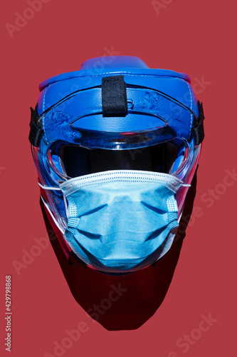 Coronavirus prevention medical surgical mask and martial arts protective helmet with clipping paths. Image illustrating fight against covid-19 and corona virus protection