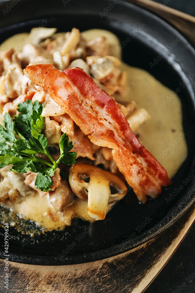 Delicious lunch, hot dish with mushrooms, potatoes and fried bacon. A hearty dinner. Beautiful still life, photo for the restaurant menu Delicious lunch, hot dish with mushrooms, potatoes and fried bacon. A hearty dinner. Beautiful still life, photo for the restaurant menu