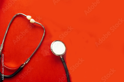 medical stethoscope isolated on red background