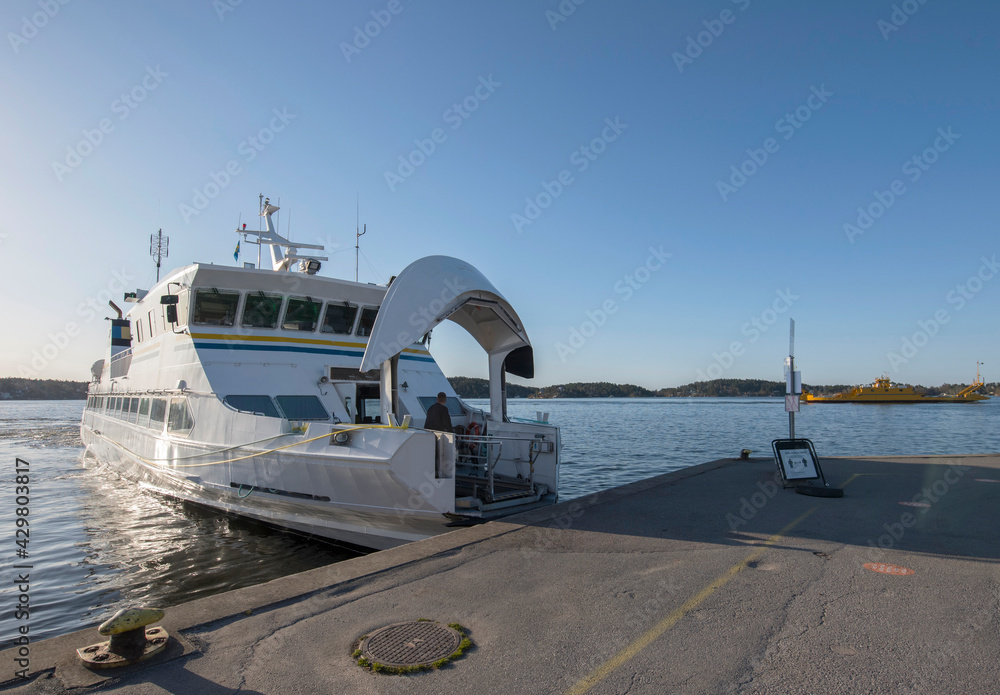 Commuting boat in the archipelago leaves the town Vaxholm heading for