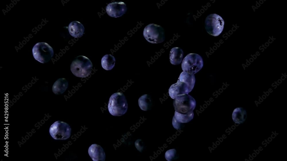 Juicy blueberries are bouncing up on the black background in slow motion Juicy blueberries are bouncing up on the black background in slow motion