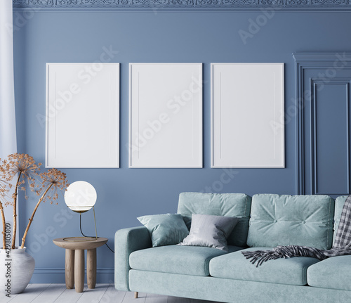 Poster frame mockup in classic blue living room with natural wooden furniture and comfy turquoise sofa, 3d render