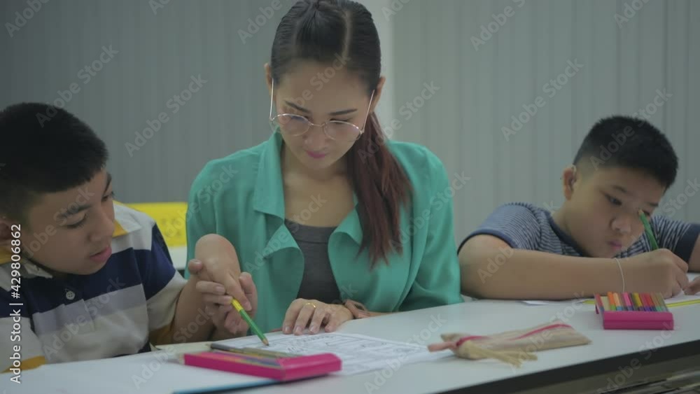 Education concept of 4k Resolution. The teacher is teaching disabled children practicing homework in the classroom. Education concept of 4k Resolution. The teacher is teaching disabled children practicing homework in the classroom.
