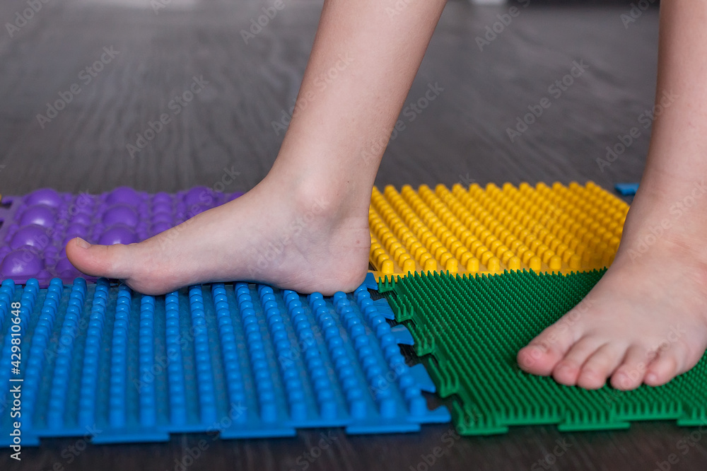Foot massage mat for babies. Prevention of flat feet and hallux valgus.  Orthopedic massage puzzle mats for the development of children Stock Photo  | Adobe Stock