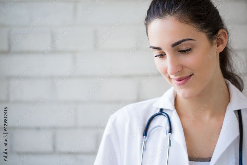 Portrait of the cheerful young brunette nurse indoors Portrait of the cheerful young brunette nurse indoors