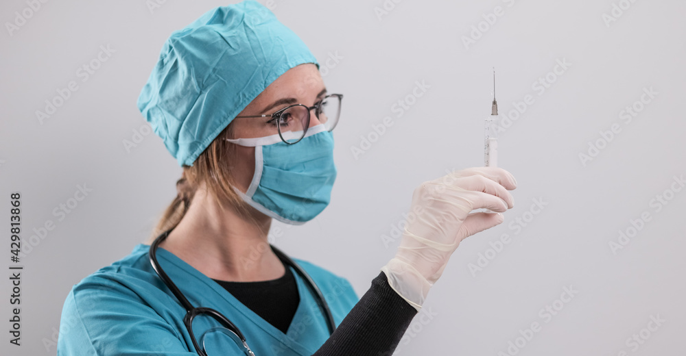 Female doctor prepares a syringe with the new Corona vaccine - studio photography Female doctor prepares a syringe with the new Corona vaccine - studio photography
