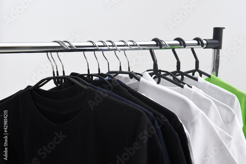 Shirts, T-shirts, clothes on hangers in the wardrobe or clothing store