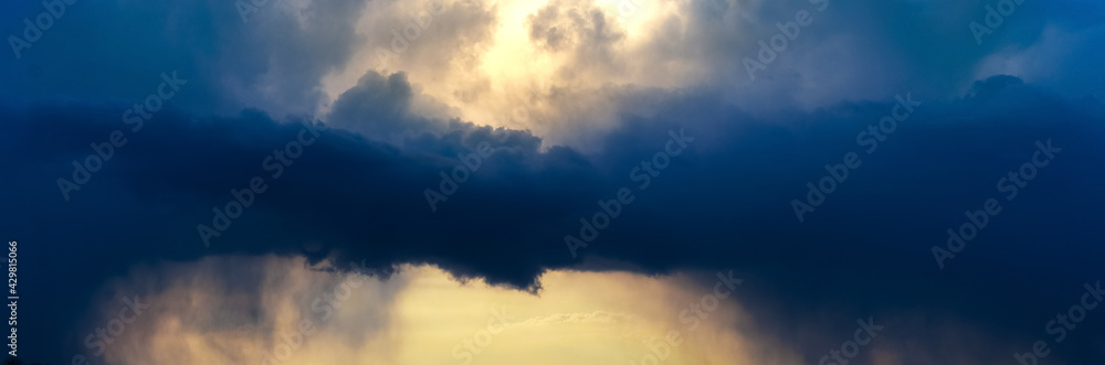 Dark storm clouds in the evening sky at sunset