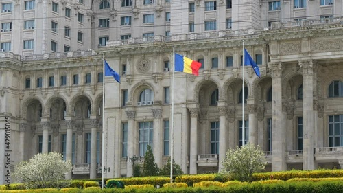 Flags Waving In Front Of Palace of the Parliament In Bucharest, Romania. medium shot photo
