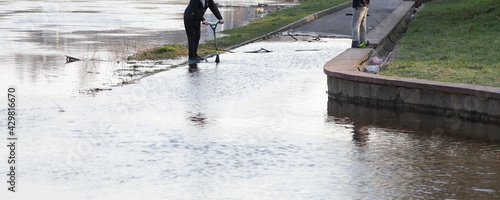 Photography Spring flood of the river, high water on the walkway road of the embankment with