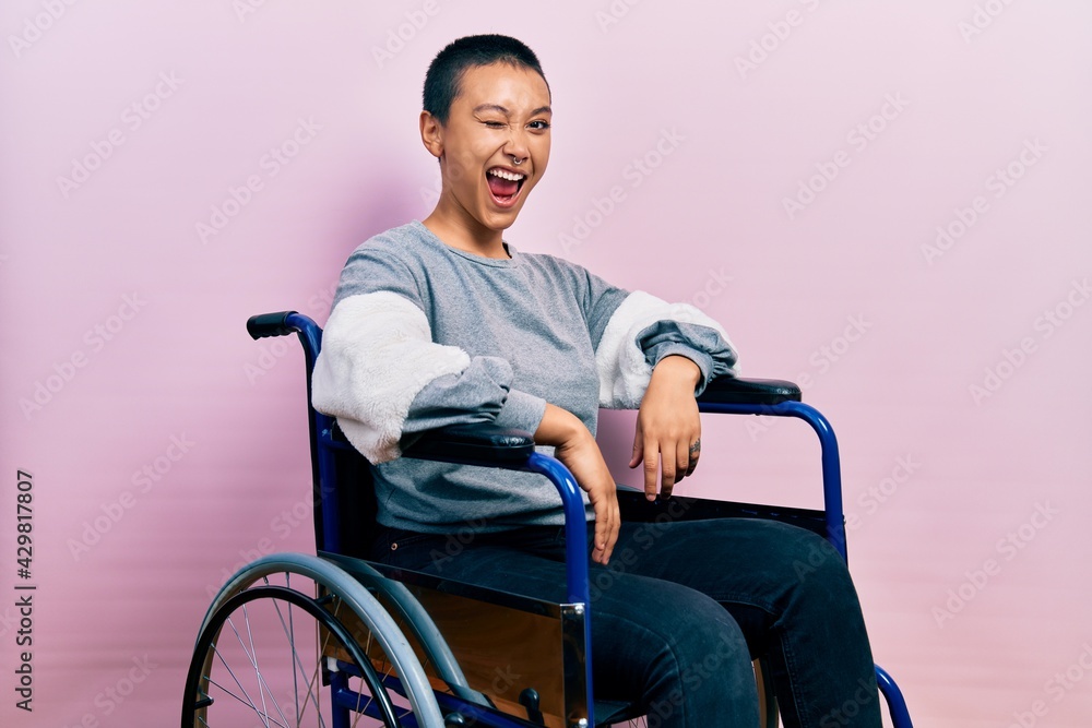 Beautiful hispanic woman with short hair sitting on wheelchair winking  looking at the camera with sexy expression, cheerful and happy face. Stock  Photo | Adobe Stock