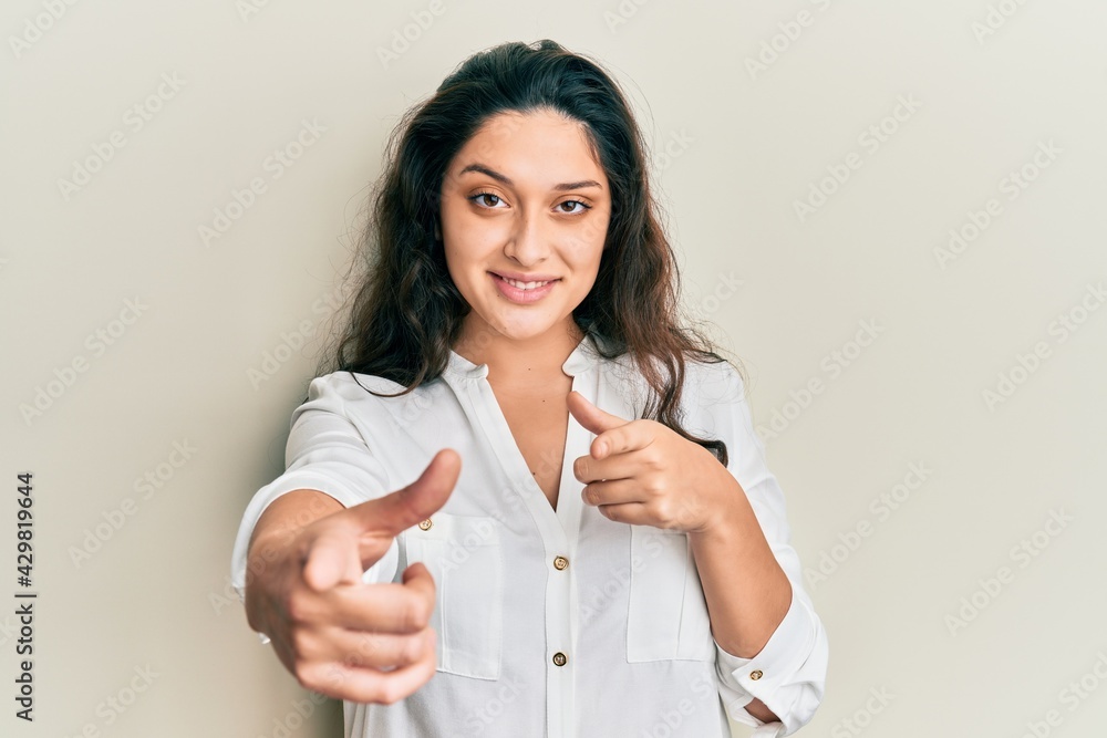 Beautiful middle eastern woman wearing casual clothes pointing fingers to camera with happy and funny face. good energy and vibes. Beautiful middle eastern woman wearing casual clothes pointing fingers to camera with happy and funny face. good energy and vibes.