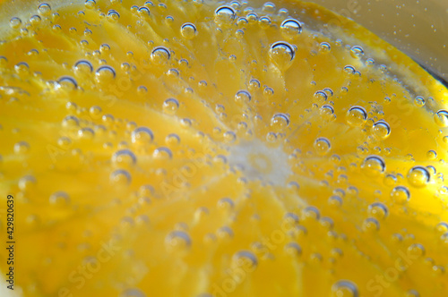 orange in sparkling water with bubbles. macro.