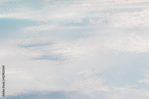 Fototapeta Naklejka Na Ścianę i Meble -  The light cloudy white sky with blue clouds of feathery and cumulus type is processed in light and soft colors. High quality photo