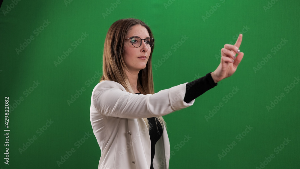Young woman taps on a large imaginary touchscreen - studio photography Young woman taps on a large imaginary touchscreen - studio photography