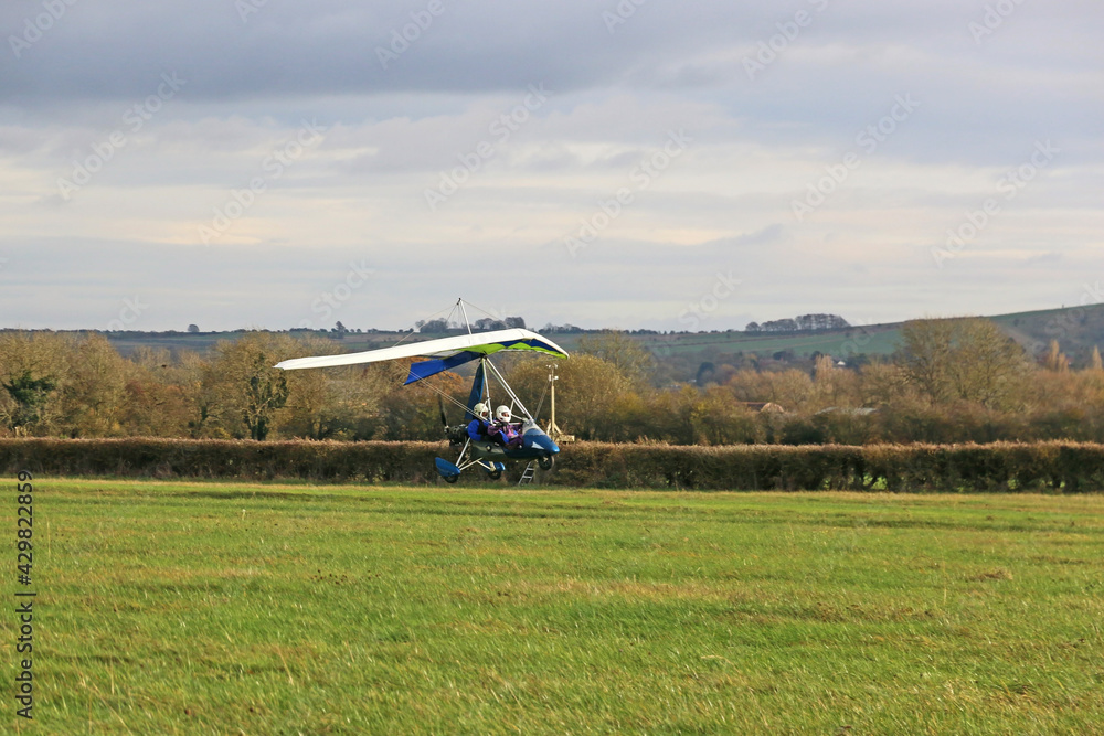 Ultralight airplane landing on a grass strip	