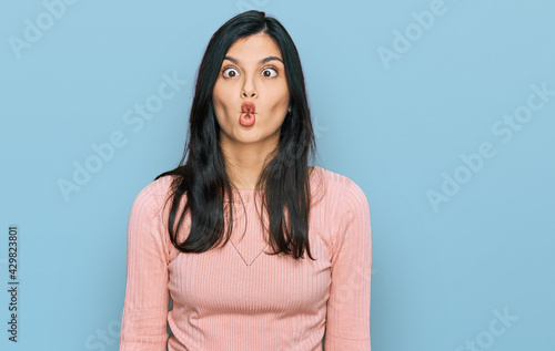 Young hispanic woman wearing casual clothes making fish face with lips, crazy and comical gesture. funny expression. © Krakenimages.com