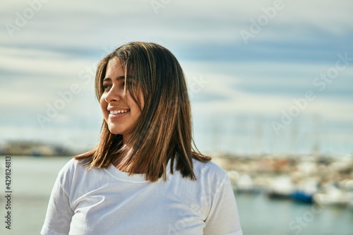 Young latin girl smiling happy standing at the beach. © Krakenimages.com