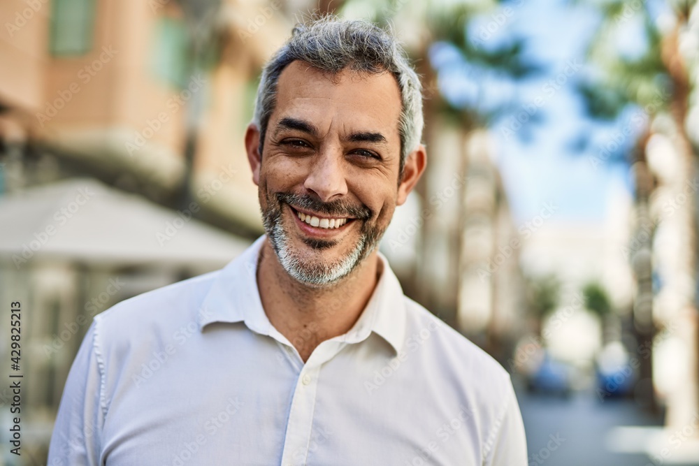 Middle age grey-haired man smiling happy standing at the city. Middle age grey-haired man smiling happy standing at the city.