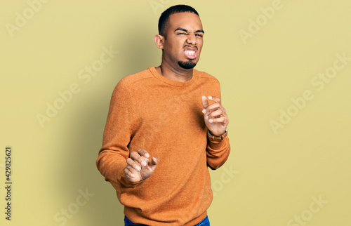 Tableau sur toile Young african american man wearing casual clothes disgusted expression, displeased and fearful doing disgust face because aversion reaction