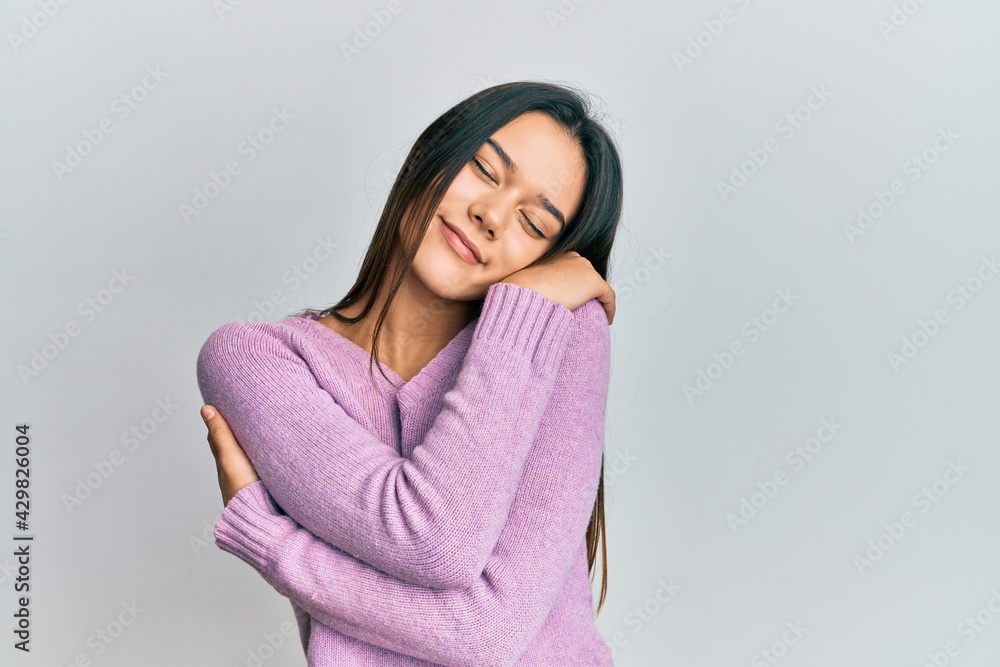 Young hispanic girl wearing casual clothes hugging oneself happy and positive, smiling confident. self love and self care Young hispanic girl wearing casual clothes hugging oneself happy and positive, smiling confident. self love and self care