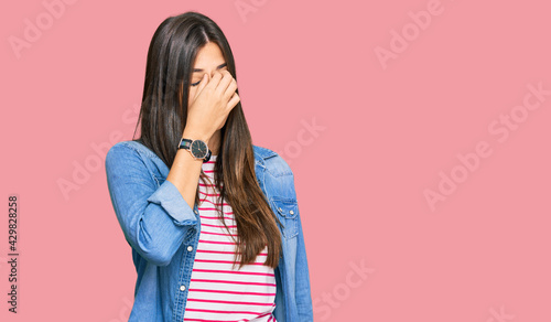 Young brunette woman wearing casual clothes tired rubbing nose and eyes feeling fatigue and headache. stress and frustration concept.