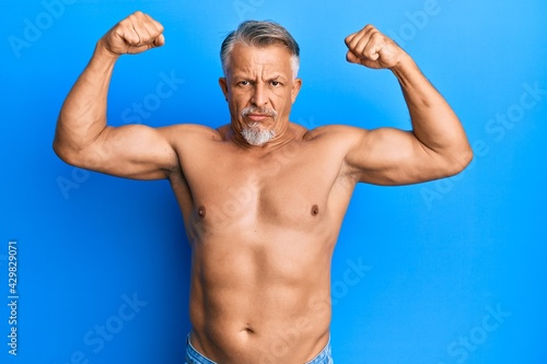 Middle age grey-haired man standing shirtless doing fitness gesture skeptic and nervous, frowning upset because of problem. negative person.