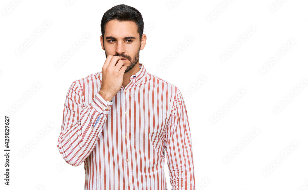 Young hispanic man wearing business shirt looking stressed and nervous with hands on mouth biting nails. anxiety problem. Young hispanic man wearing business shirt looking stressed and nervous with hands on mouth biting nails. anxiety problem.