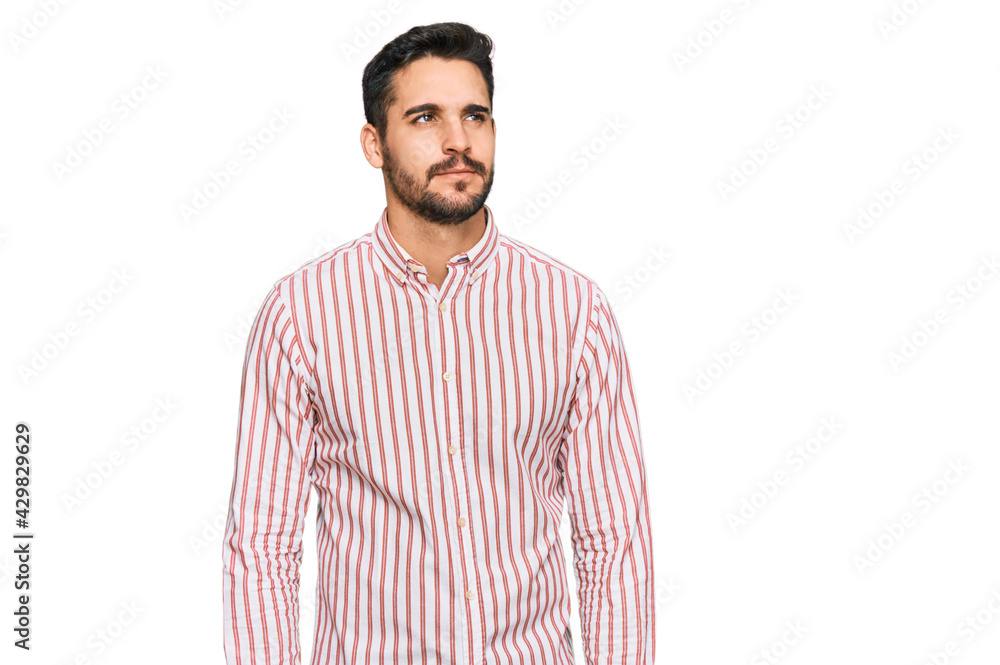 Fototapeta premium Young hispanic man wearing business shirt smiling looking to the side and staring away thinking.