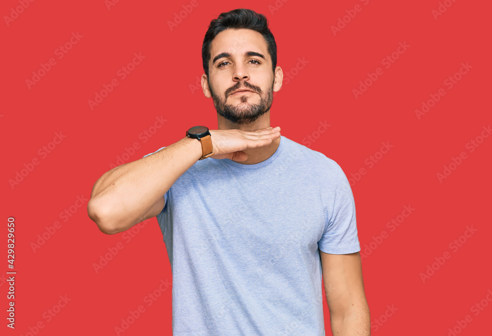Young hispanic man wearing casual clothes cutting throat with hand as knife, threaten aggression with furious violence Young hispanic man wearing casual clothes cutting throat with hand as knife, threaten aggression with furious violence
