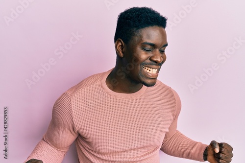 Handsome black man wearing casual clothes very happy and excited doing winner gesture with arms raised, smiling and screaming for success. celebration concept.