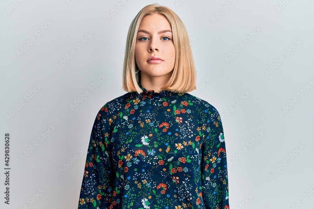 Young blonde woman wearing casual clothes relaxed with serious expression on face. simple and natural looking at the camera. Young blonde woman wearing casual clothes relaxed with serious expression on face. simple and natural looking at the camera.