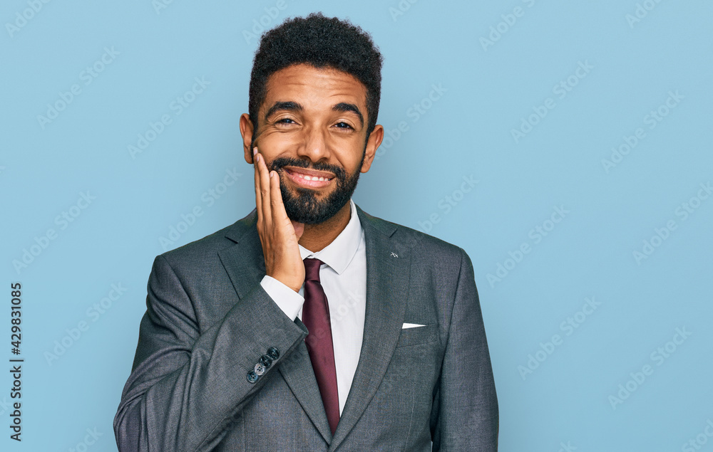 Young african american man wearing business clothes touching mouth with hand with painful expression because of toothache or dental illness on teeth. dentist Young african american man wearing business clothes touching mouth with hand with painful expression because of toothache or dental illness on teeth. dentist