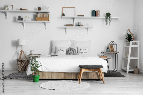 Interior of modern bedroom with tables and houseplants