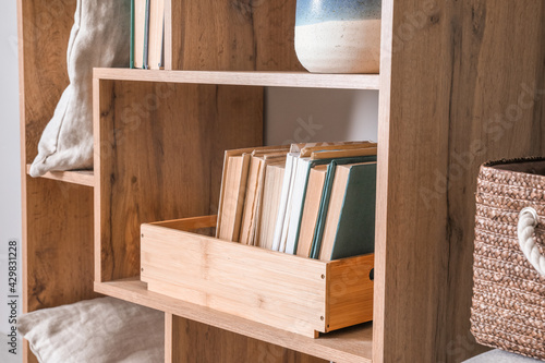 Wooden shelf with books and decor, closeup