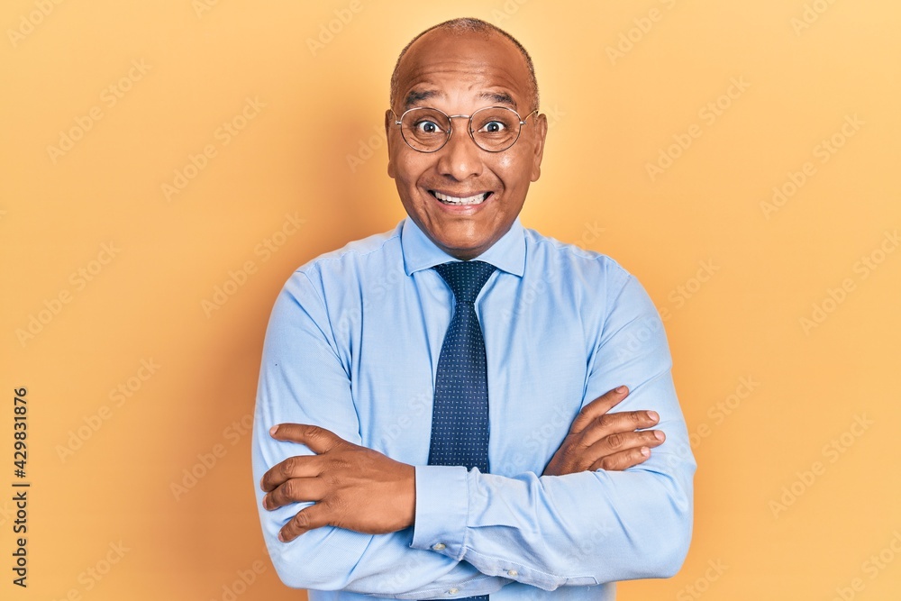 Middle age latin man wearing business clothes with arms crossed gesture celebrating crazy and amazed for success with open eyes screaming excited. Middle age latin man wearing business clothes with arms crossed gesture celebrating crazy and amazed for success with open eyes screaming excited.