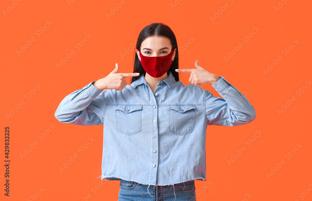 Stylish young woman wearing mask on color background Stylish young woman wearing mask on color background