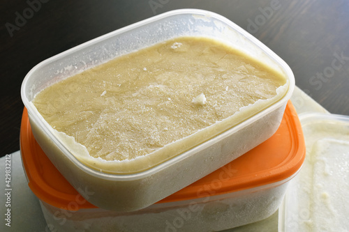 Frozen soup in a plastic box container.  Potato leek soup in a box.  Photo can be used for the concept of is frozen food healthy to eat or how do you keep frozen food fresh. 