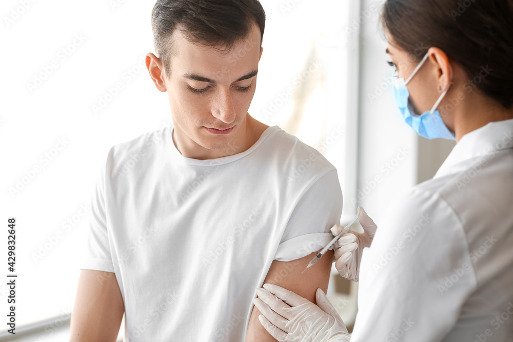 Doctor vaccinating patient against covid-19 in clinic Doctor vaccinating patient against covid-19 in clinic