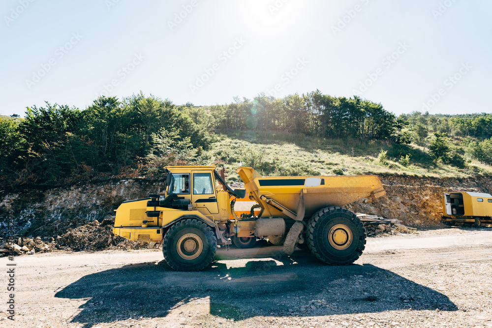 Yellow quarry dump truck driving on the road