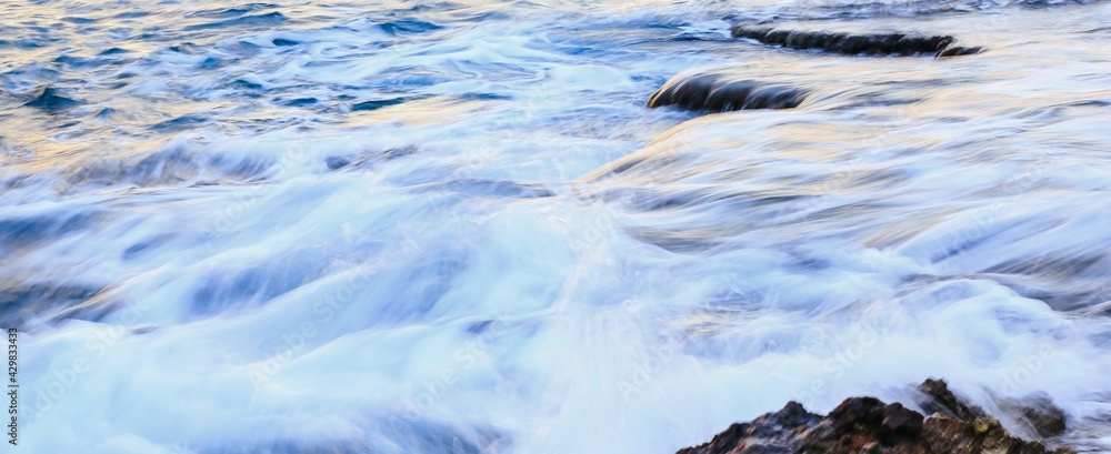 Blurred abstract natural background of sea water with waves and foam. Motion blur. Nature. Banner. Blurred abstract natural background of sea water with waves and foam. Motion blur. Nature. Banner.