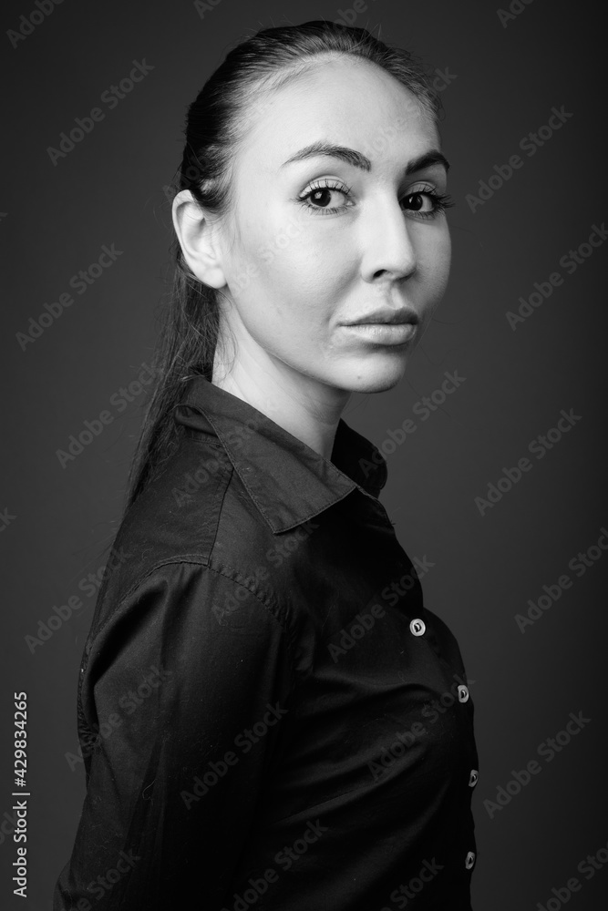 Studio shot of young beautiful businesswoman in black and white