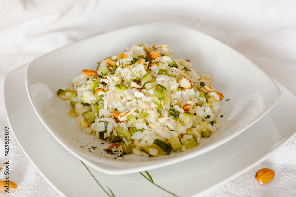 Vegan zucchini risotto with almonds in a white ceramic dish-1 Vegan zucchini risotto with almonds in a white ceramic dish-1